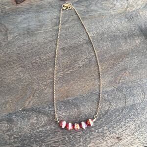 Red and white iridescent faceted beaded necklace on a gold tone chain